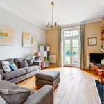 Spacious living room with fireplace and garden view.