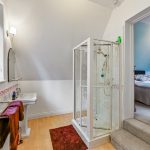 Modern bathroom with shower, view into bedroom.
