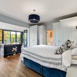 Luxury bedroom with large windows and elegant decor.