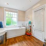 Modern bathroom with bathtub and wooden floor