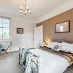 Cosy bedroom with double bed and chandelier lighting.