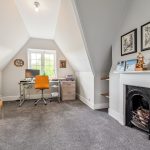 Cosy attic office with desk and fireplace