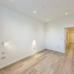 Empty room with wooden floor and white walls.