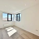 Bright empty room with large windows and wood floor.