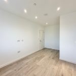 Empty room with wooden floor and white walls.