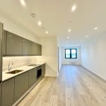 Modern kitchen and living area with wooden flooring.