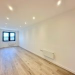 Spacious modern flat with wooden flooring and window.