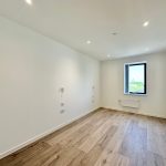 Empty room with wooden floor and window view.