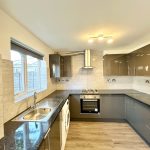 Modern kitchen with grey cabinets and appliances.