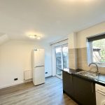 Modern kitchen with large window and appliances.