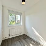 Small empty room with wooden floor and window