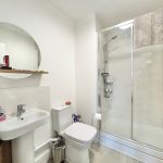 Modern bathroom with shower, sink, and toilet.