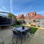 Outdoor patio with trampoline and garden furniture