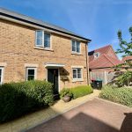 Modern brick house with garden and bins outside.