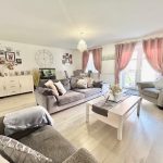 Bright living room with grey sofas and pink curtains