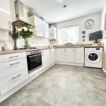 Modern kitchen with appliances and decorative elements.