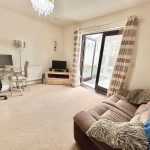 Cosy living room with desk and TV area.