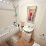 Small bathroom with a bathtub, sink and mirror.