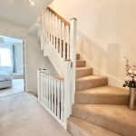 Bright hallway with staircase and bedroom view