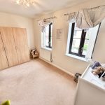 Bright children's bedroom with wardrobe and toys.