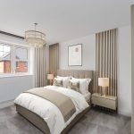 Modern bedroom with beige decor and large window.