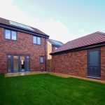Modern brick house with solar panels and garden
