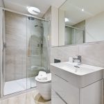 Modern bathroom with shower, sink, toilet.