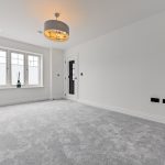Spacious room with grey carpet and chandelier