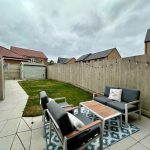 Modern backyard with outdoor seating area and lawn.