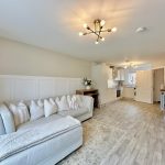 Modern living room and kitchen with beige sofa.