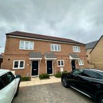 Modern semi-detached brick houses with parking.