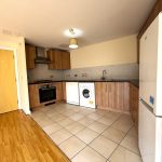 Modern kitchen with appliances and wooden cabinets.
