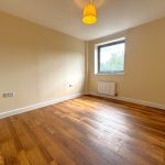 Empty room with wooden floor and window.