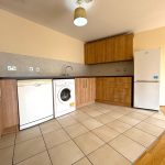 Modern kitchen with appliances and wooden cabinets.