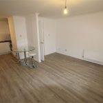 Modern open-plan kitchen and living area with laminate flooring.