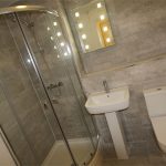 Modern bathroom with shower, sink and toilet.
