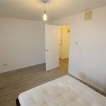 Minimalist bedroom with open door and mattress