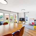 Bright living room with dining area and balcony view.
