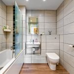 Modern bathroom with bathtub, sink, toilet, heated towel rail.