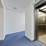 Open elevator in a bright white hallway.