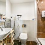Modern bathroom with shower, sink, and toilet.