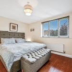 Cosy bedroom with double bed and window view.