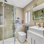 Modern bathroom with glass shower cubicle and elegant sink.