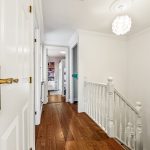 Bright hallway with wooden floors leading to rooms.