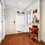 Bright hallway with wooden floor and red furniture