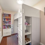 Children's bedroom with bunk bed and bookshelf.