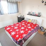 Cosy bedroom with red snowflake blanket.
