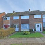 Row of brick terrace houses with gardens.
