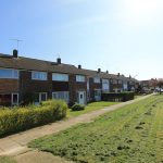 Terraced houses with gardens on sunny day.