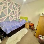 Cosy bedroom with geometric wall design.